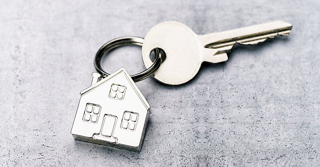 Nyckel på en nyckelknippa med en nyckelring av ett hus