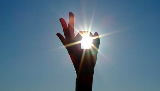 hand gör ett tecken för perfekt framför solen